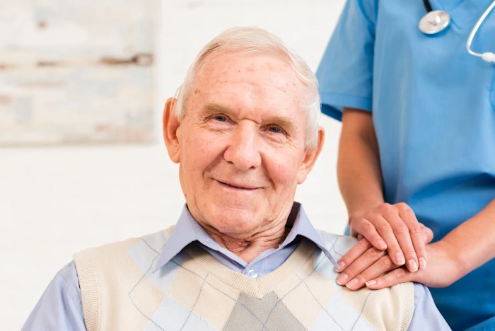 caregiver holding old man's shoulder